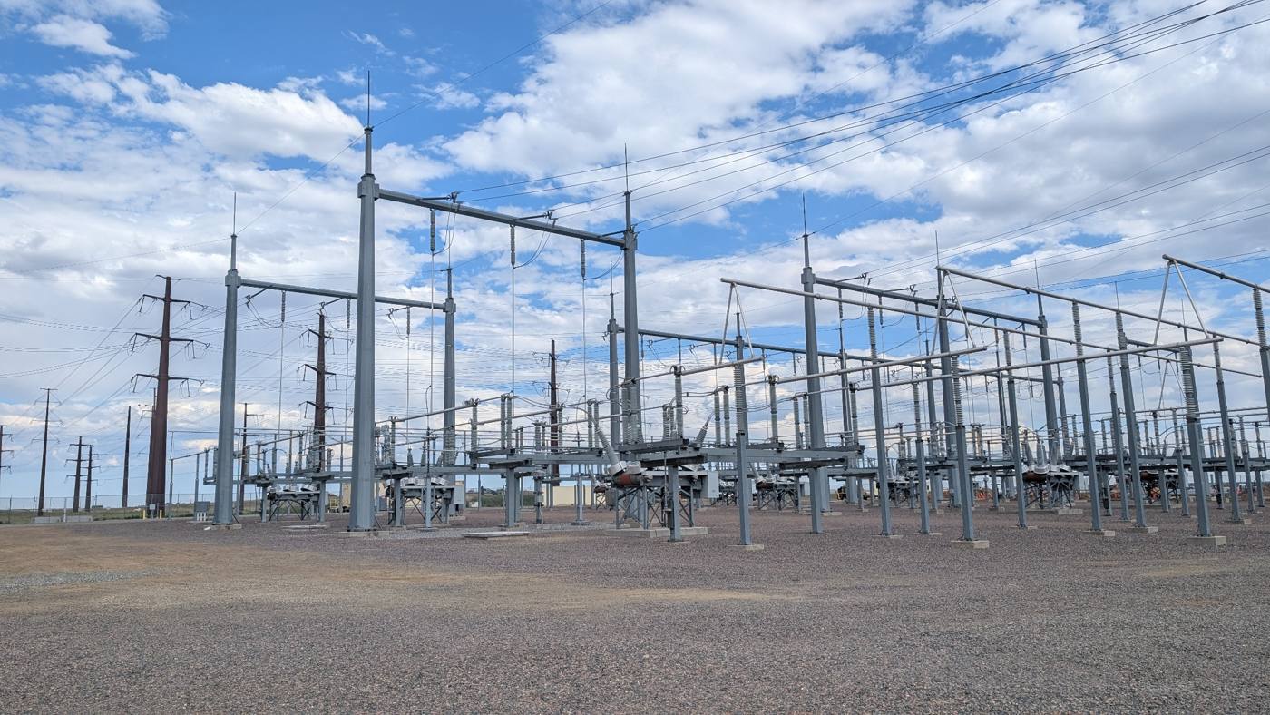 Large high-voltage substation under a partly cloudy sky